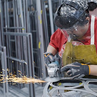 a worker at jada windows grinding a metal frame